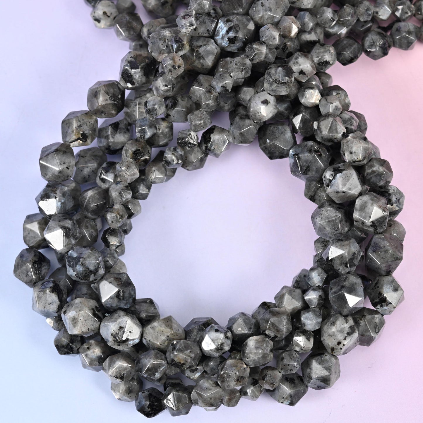 Black Labradorite faceted diamond star cut beads, close view of the coiled strands showing smoky grey with dark speckling