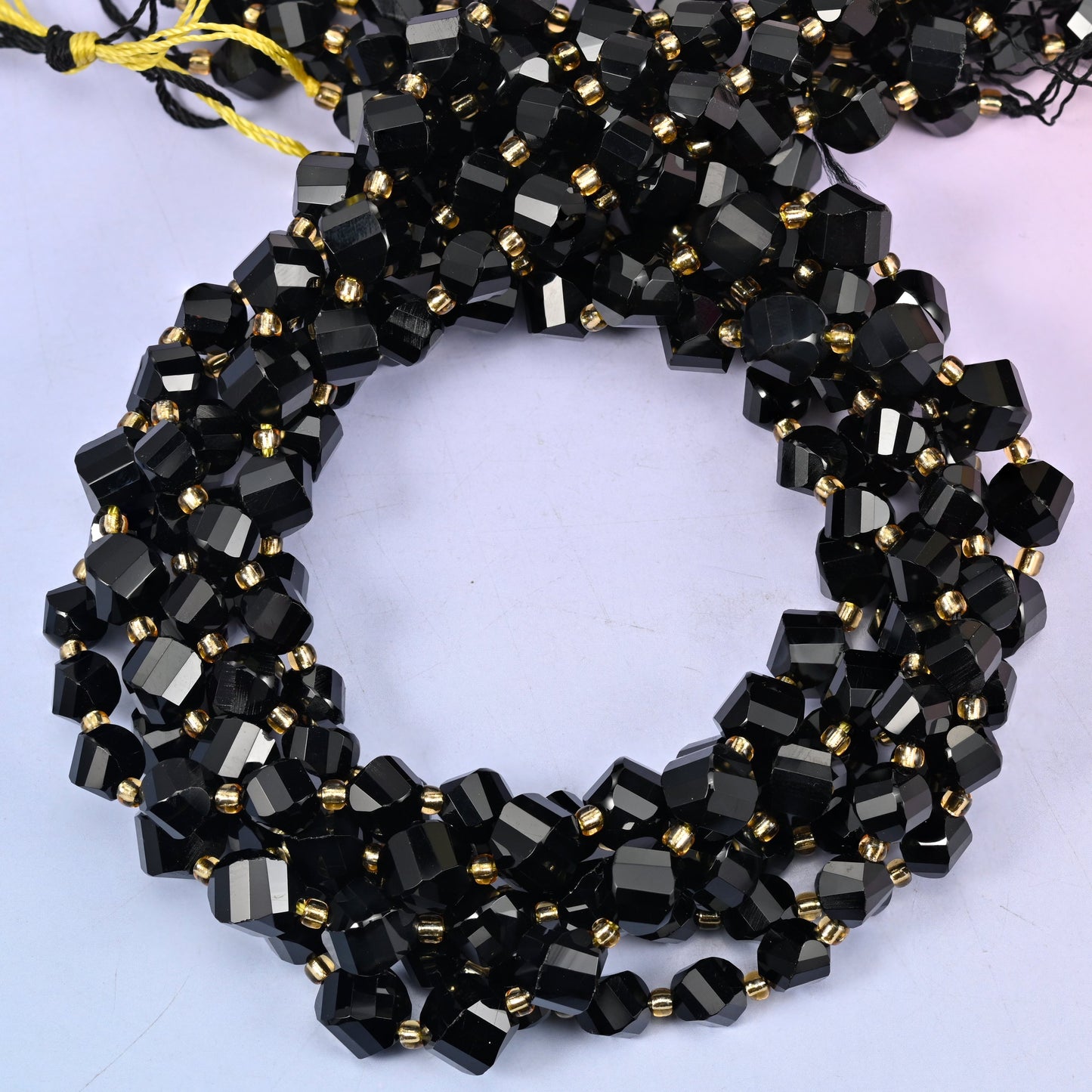Black Onyx faceted spiral twist beads, close view of the coiled strands in glossy black with gold spacer beads