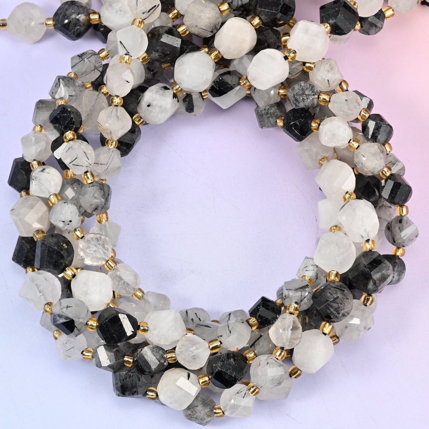 Black Rutilated Quartz faceted spiral twist beads, close view of the coiled strands showing milky white quartz with black needle inclusions