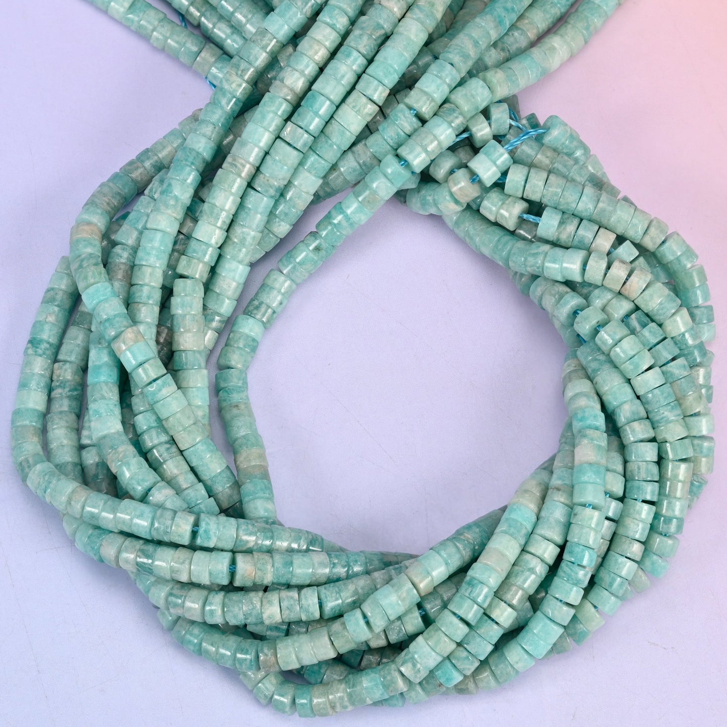 Blue Amazonite smooth heishi disc beads, close view of the coiled strands showing the soft sea-green colour