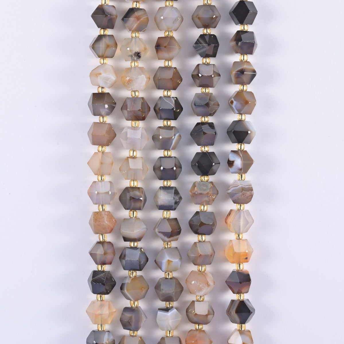 Faceted 8 sided diamond rhombus beads hanging in strands, mixed grey, cream and brown stone with gold spacers