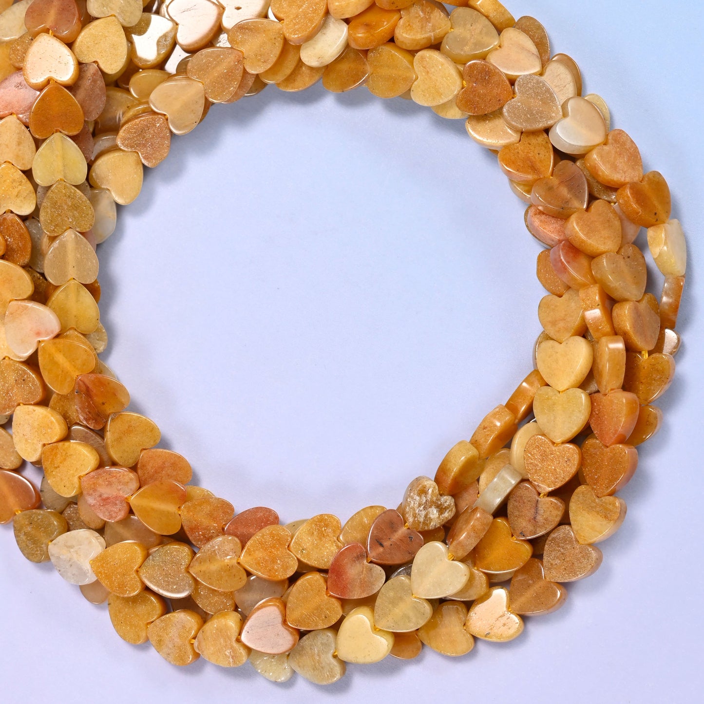 Gold Silk Jade flat heart beads, close view of the coiled strands in honey gold and cream