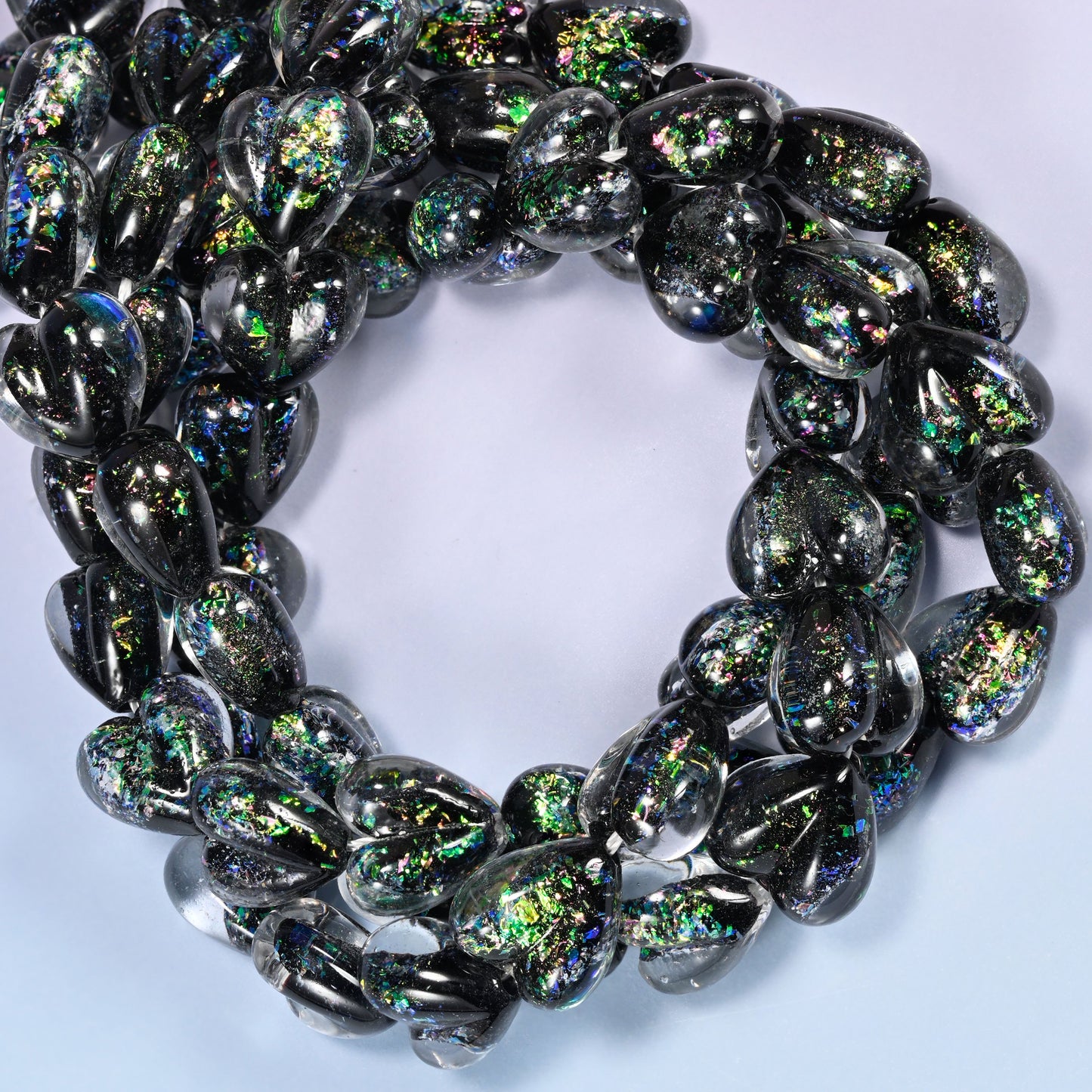 Iridescent Black Green Heart glass beads, close view of the coiled strands in black with green and gold glitter inclusions