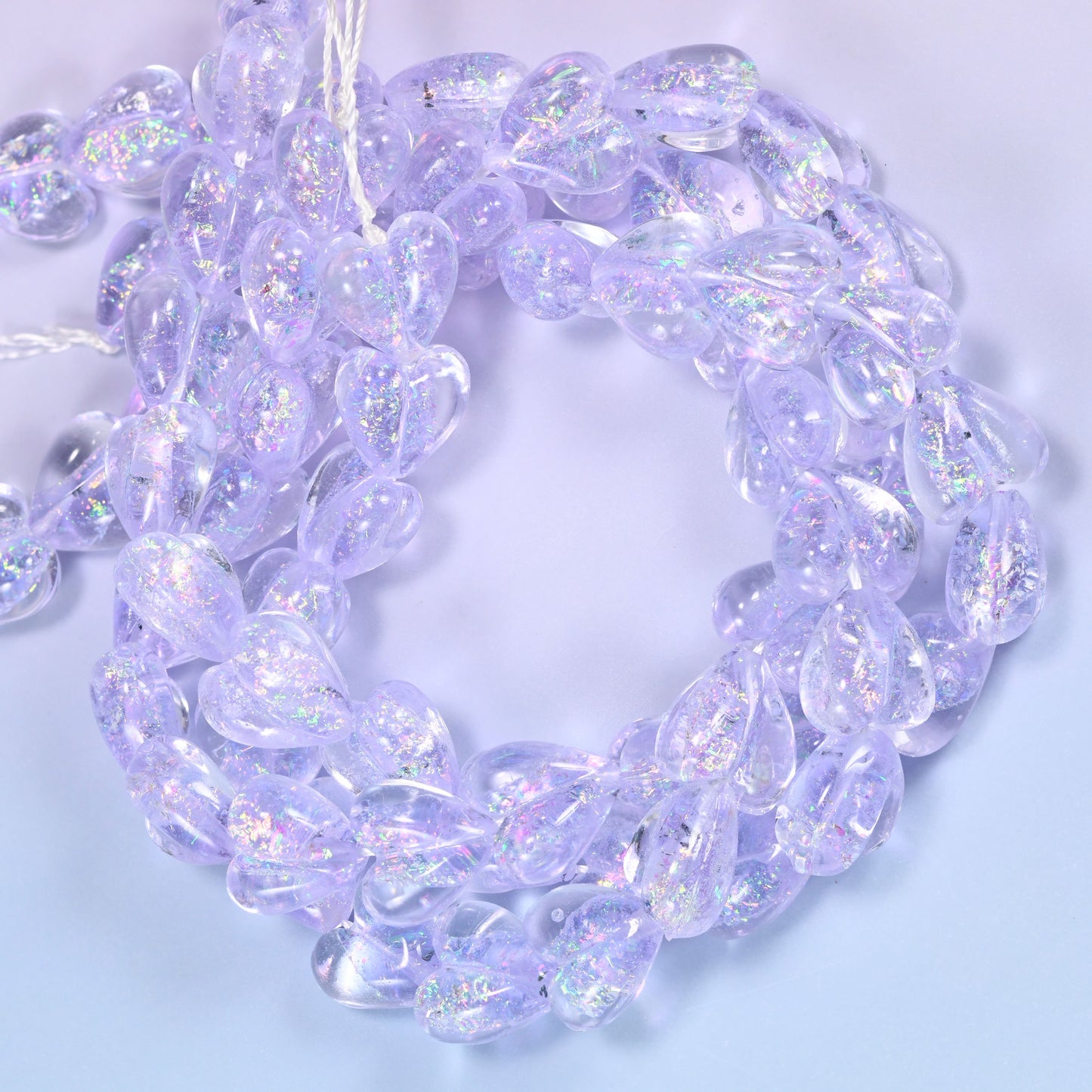 Iridescent Light Purple Heart glass beads, close view of the coiled strands in soft lilac with glitter inclusions