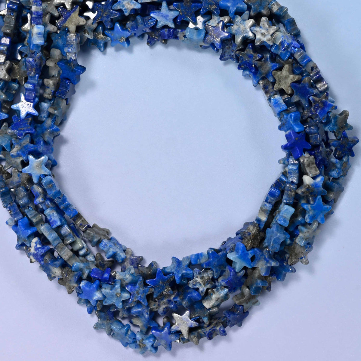 Lapis Lazuli flat star beads, close view of the coiled strands in deep blue with grey marbling