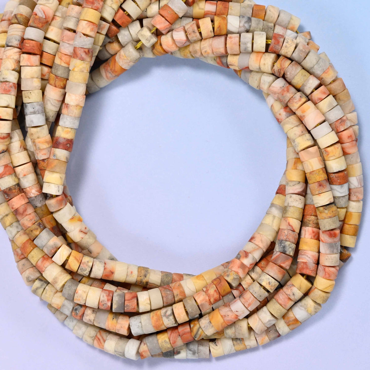 Matte Crazy Agate heishi disc beads, close view of the coiled strands mixing cream, tan and soft apricot