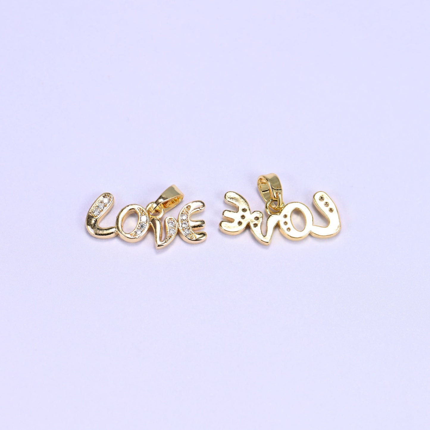 Gold Love letter zirconia charms shown front and back, one script pendant face up and the second flipped to reveal the reverse.