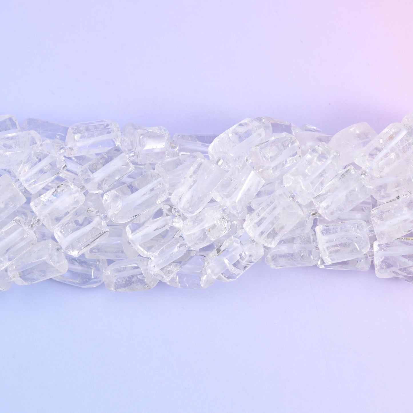 Strands lying in a shallow S, frosted fracture lines catching light inside otherwise glassy beads