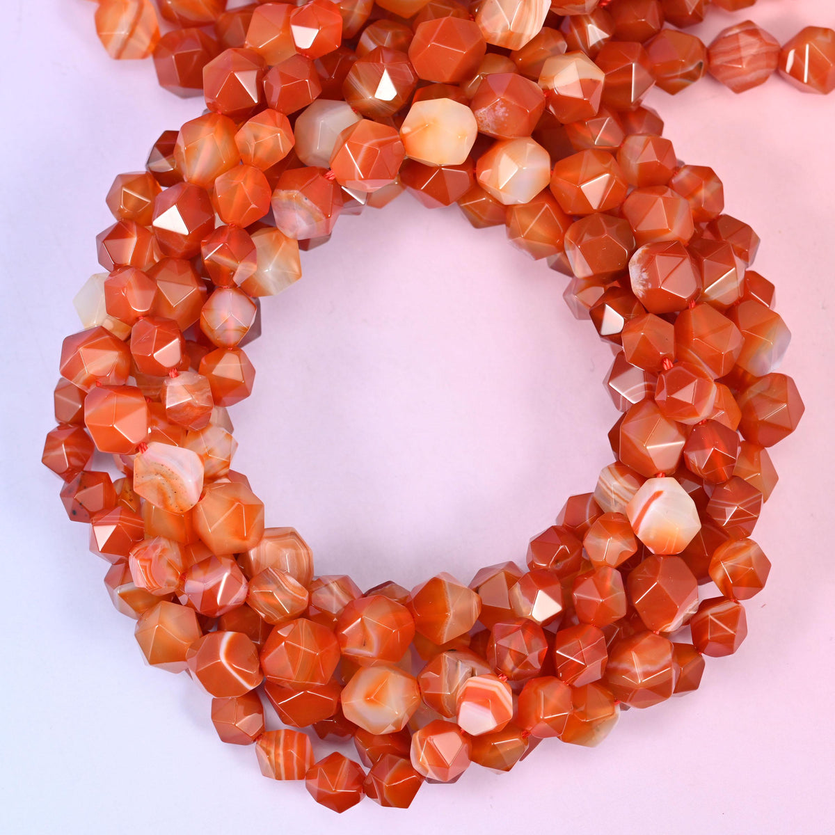 Dyed Red Stripe Agate star cut beads coiled in a loop, approximately 38 beads per 10mm strand
