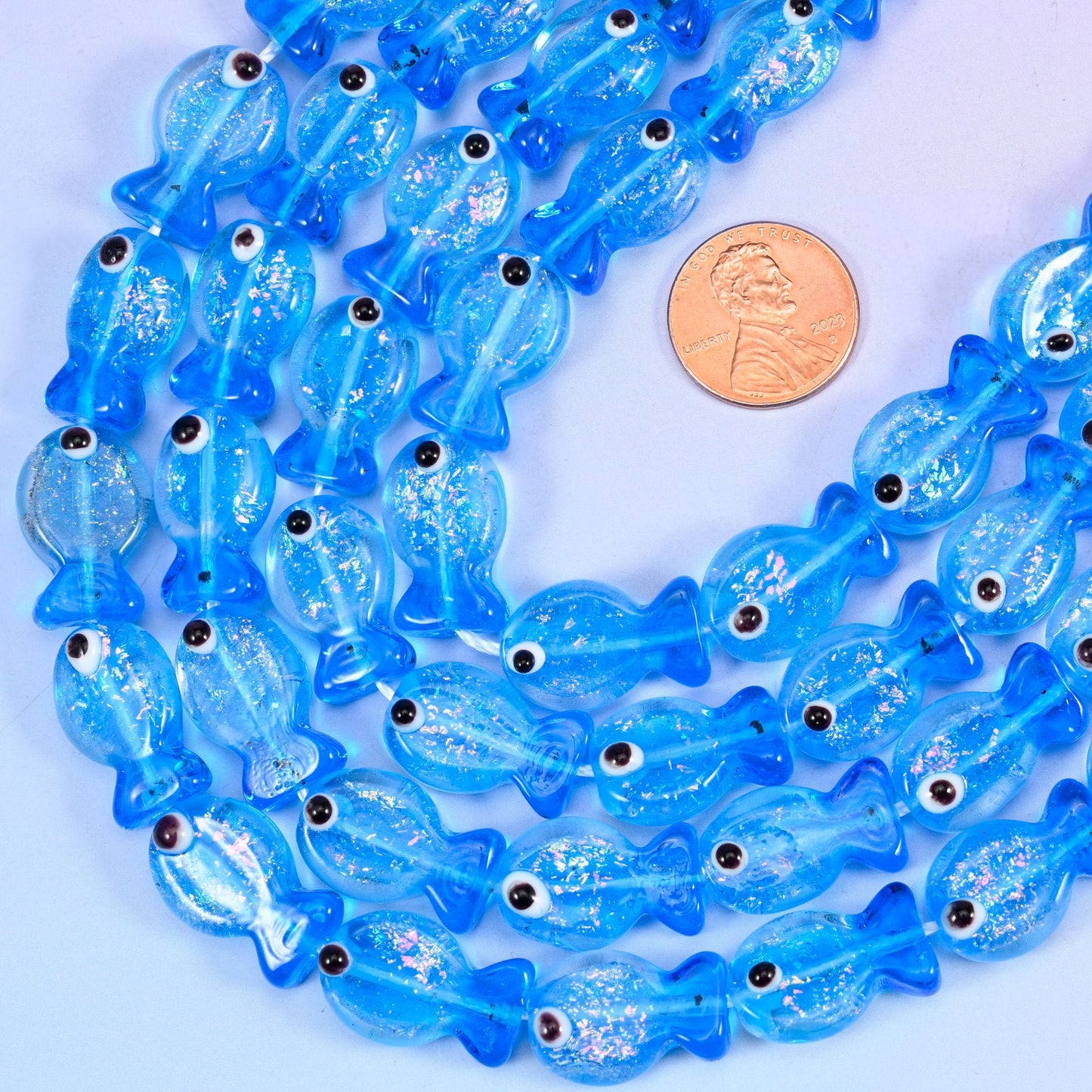 Fish shaped blue glass beads with a moulded fanned tail