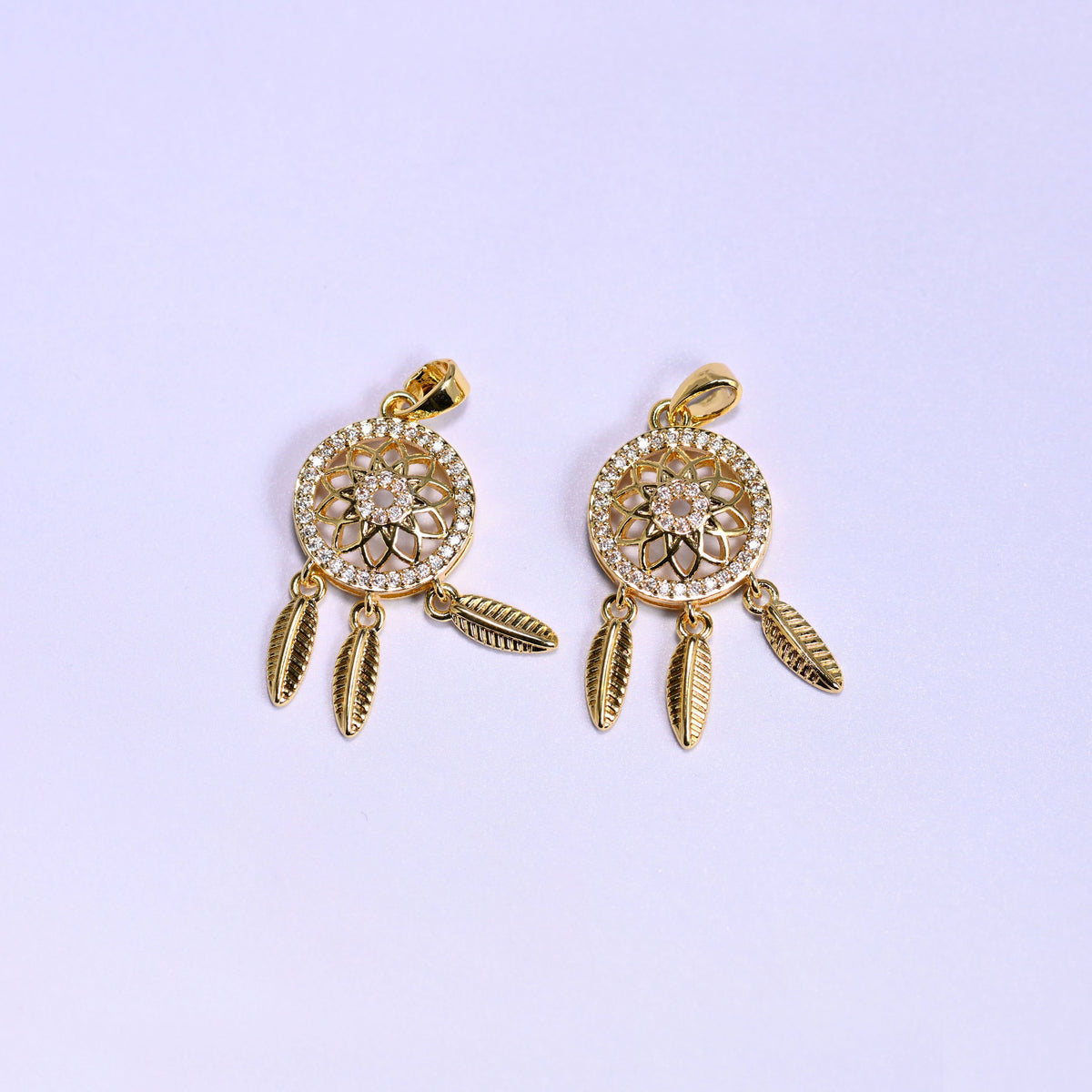 Two gold Dream Catcher Zirconia Charms side by side, 18K gold plated medallions set with clear zirconia pave and hung with feather dangles.