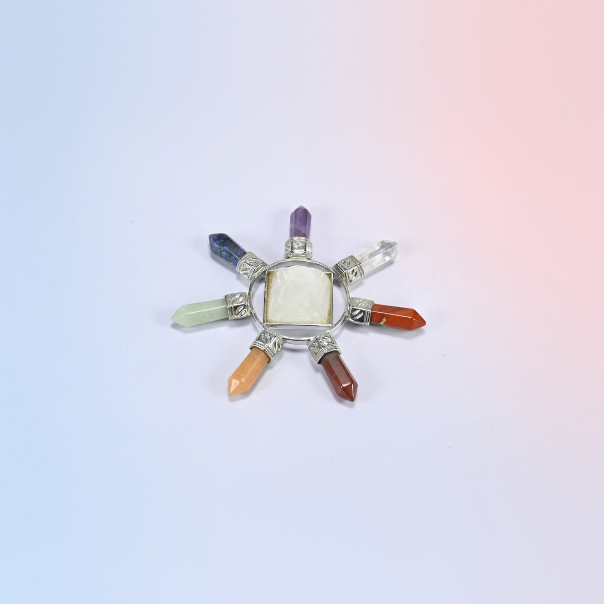Crystal energy generator with a clear quartz center pyramid and seven chakra crystal points in a silver-tone frame