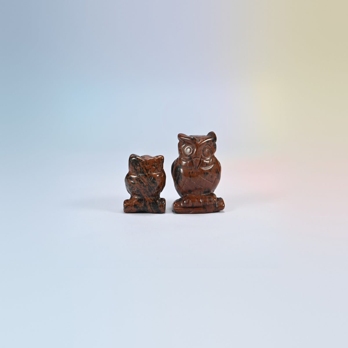 Owl crystal carving in golden swan, red-brown natural stone with dark speckles