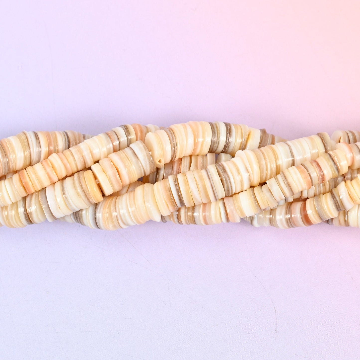 Natural Shell Round Disc Spacer Beads, thin heishi-style discs in warm cream, sand, taupe and blush, each carrying the shell's own fine growth lines.