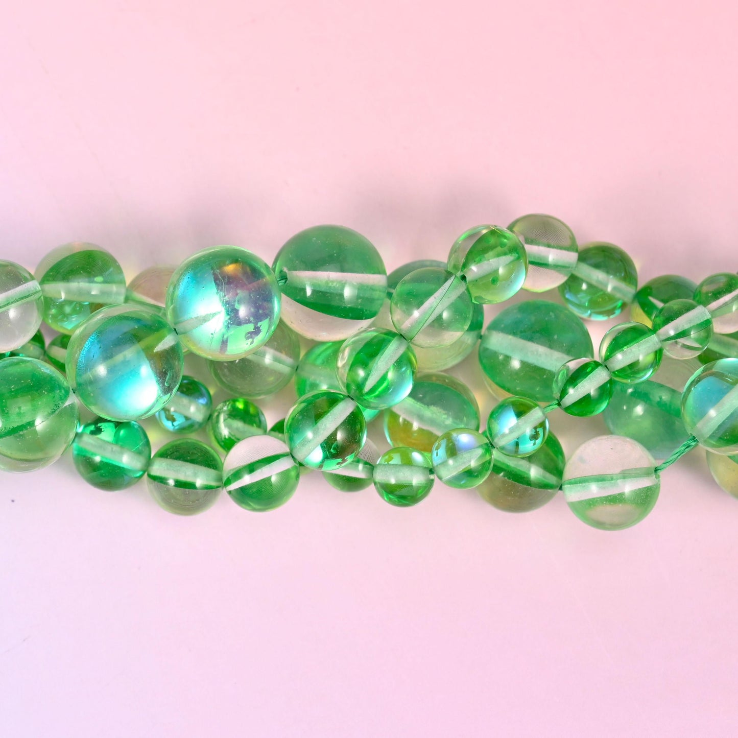 Clear apple-green glass beads finished with an iridescent aura coating