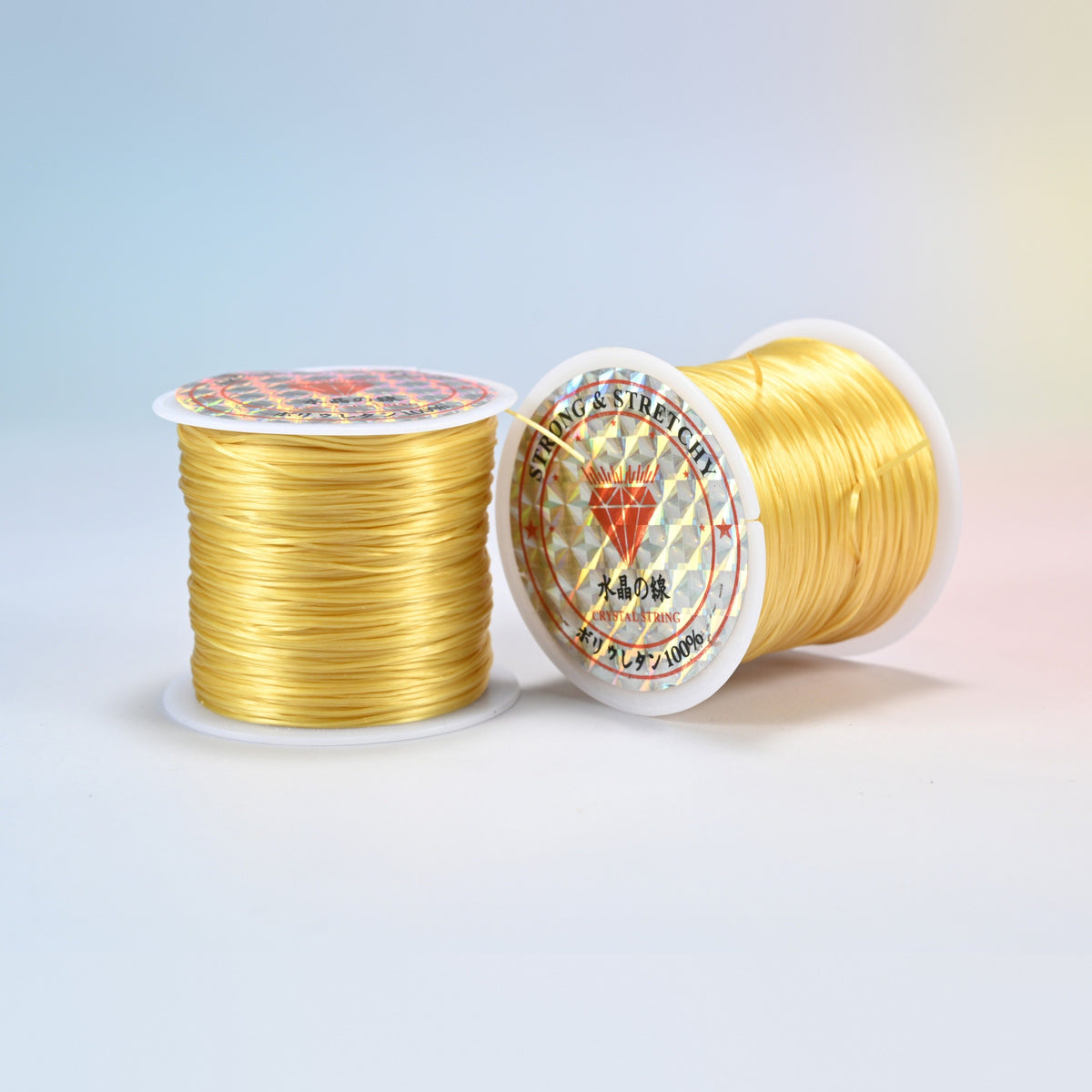 Two rolls of light gold 0.7-0.8mm elastic stretch string, glossy polyurethane bead cord with a holographic label