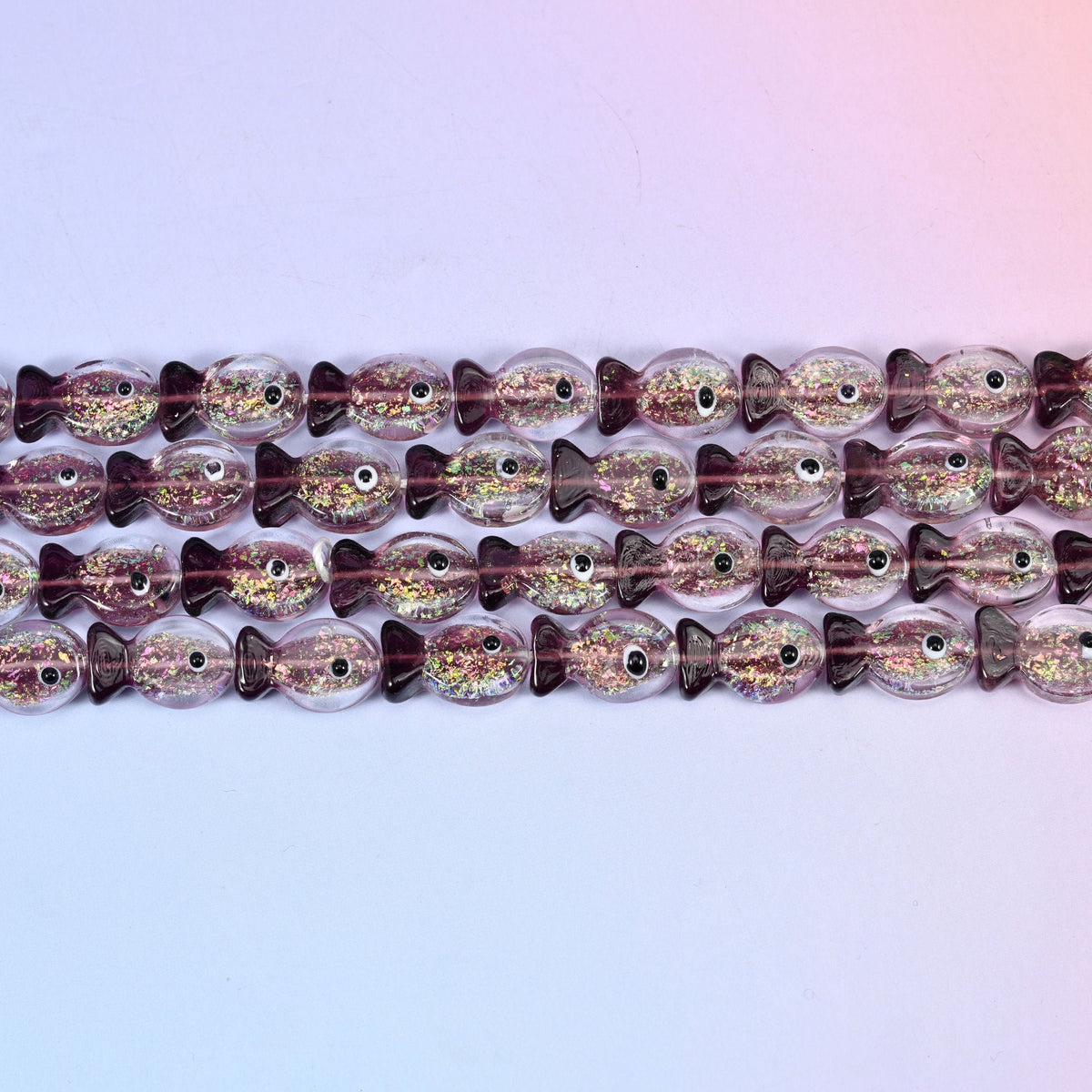 Iridescent purple fish glass beads in amethyst-tinted glass with green and gold glitter foil