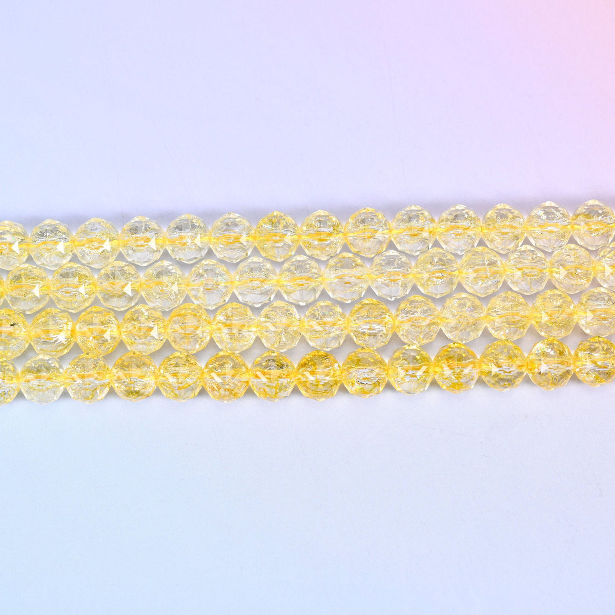 Transparent yellow faceted round glass beads in clear lemon-to-champagne