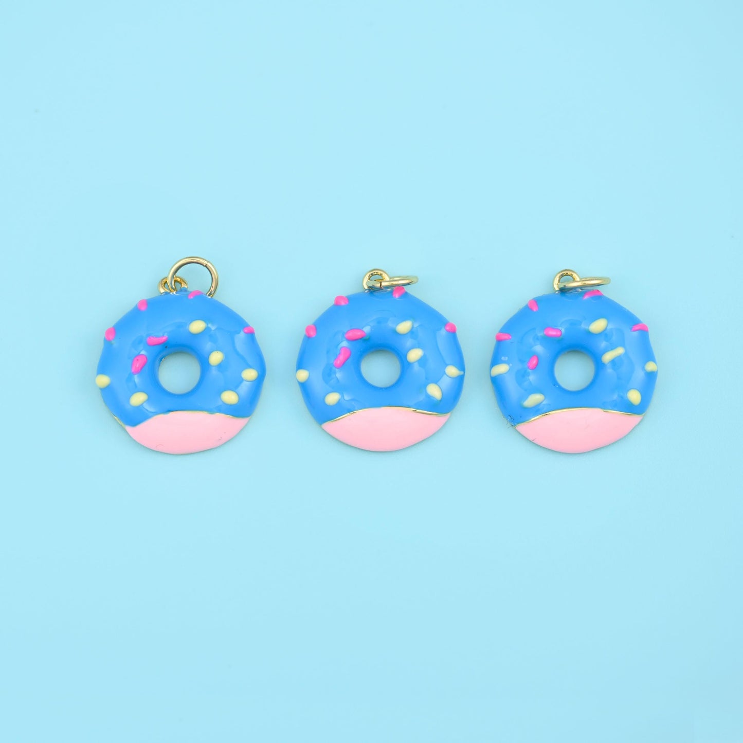 A glossy enamel doughnut half-dipped in chocolate brown icing and scattered with pastel sprinkles