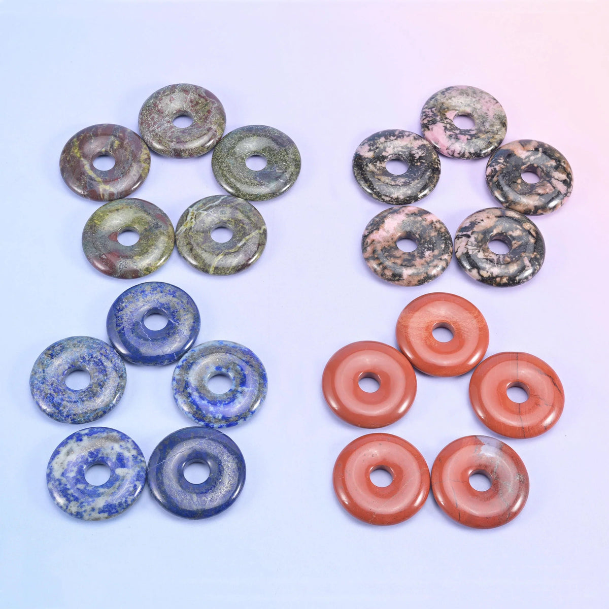 Green and grey speckled donuts beside deep blue lapis and terracotta red aventurine