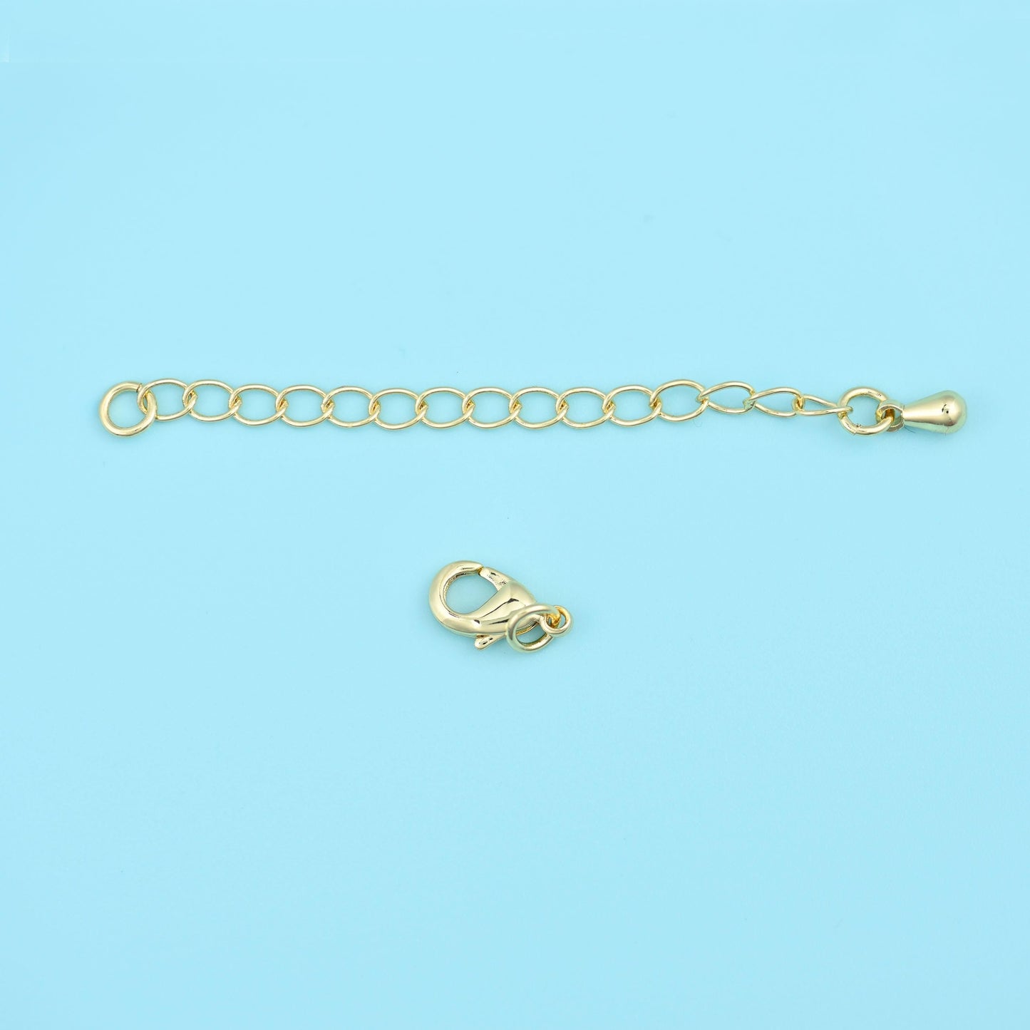 A short run of open oval links in warm gold, with a lobster clasp at one end and a small tag at the other. Add it to a finished necklace to gain length