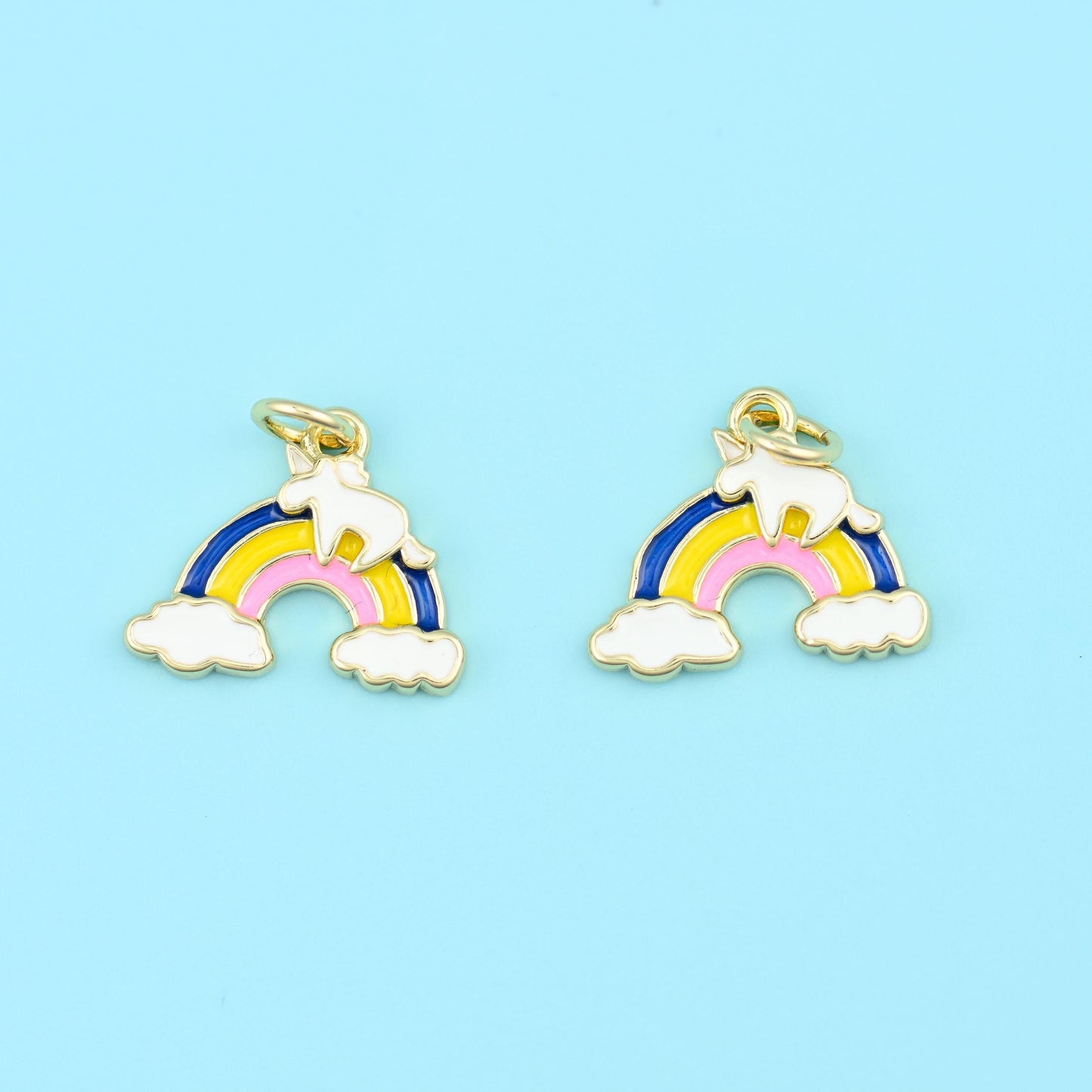 An arched rainbow sitting on two white enamel clouds, banded in glossy enamel and outlined in bright 18K gold filled brass…