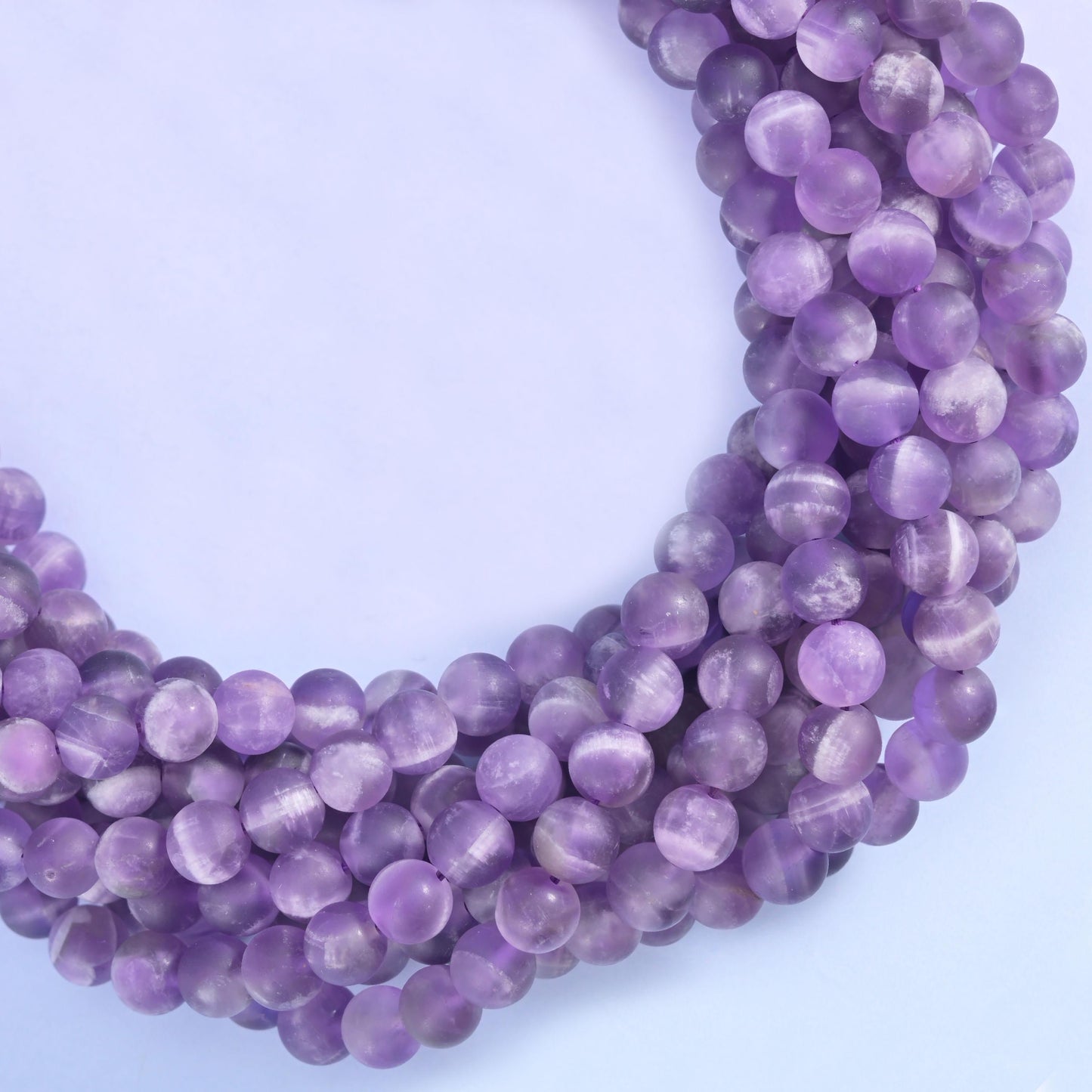 Soft lavender and grape purple rounds banded with chalky white, the stripes running in wide V shapes across each bead. Sanded to a matte finish that turns the purple powdery and mutes it right down.