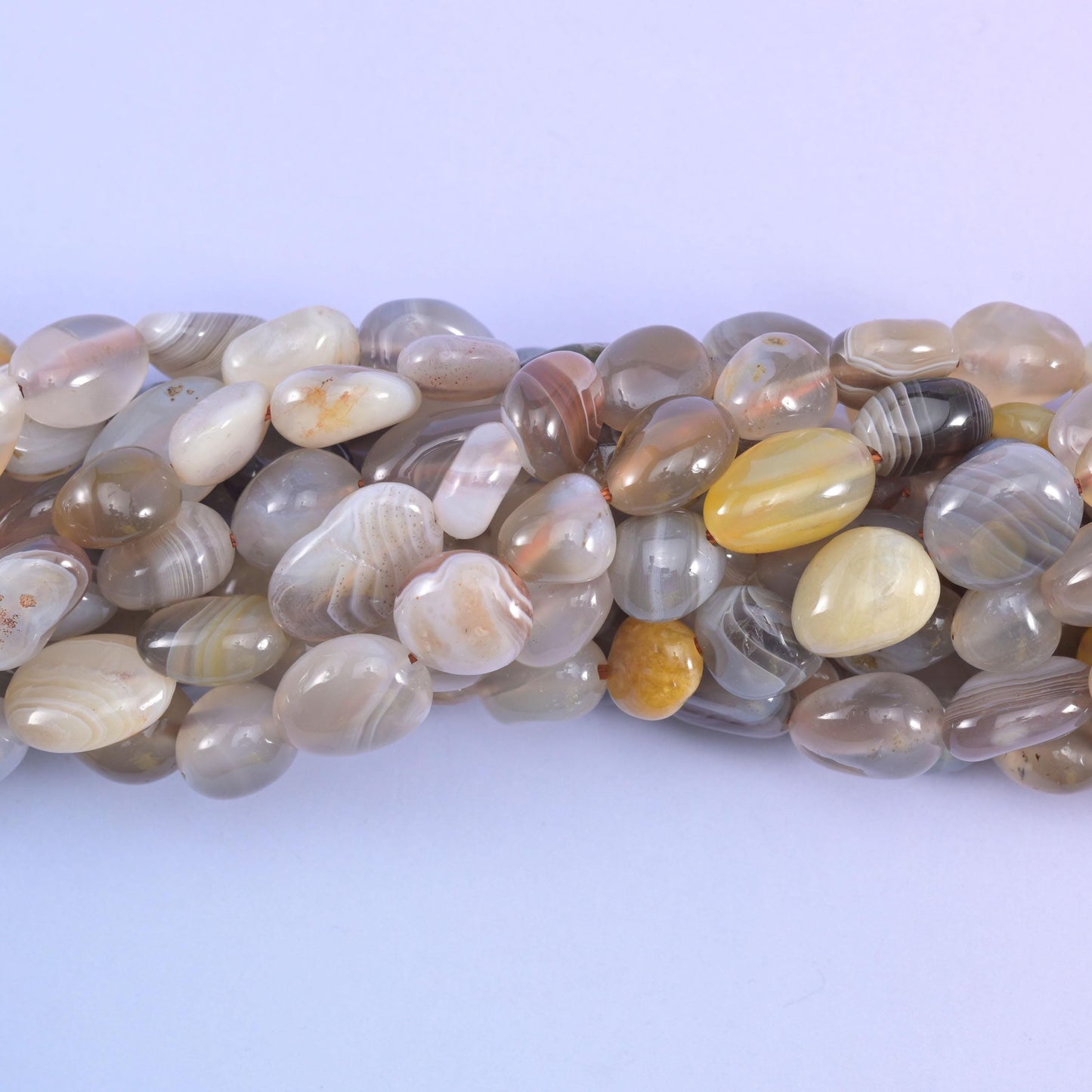 Close view of banded Botswana Agate nuggets with fine white stripes