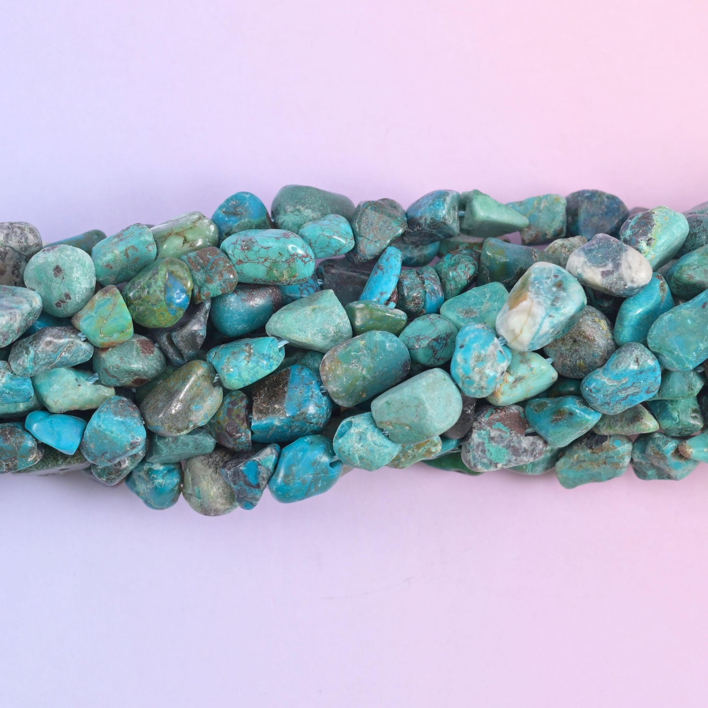 Macro of the nugget faces, sea green stone crossed by charcoal and rust veining