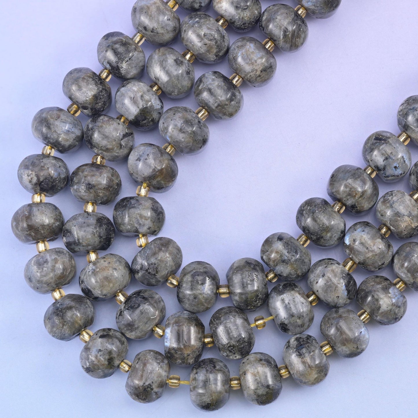 Two strands curving on a soft blue backdrop, the ribbed melon shape clear along each bead