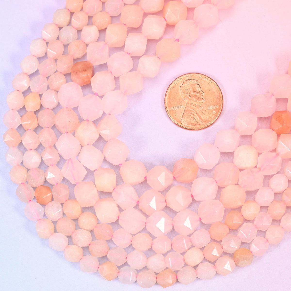 Pink Aventurine star cut beads with a US penny alongside for size reference, available in 6mm, 8mm and 10mm