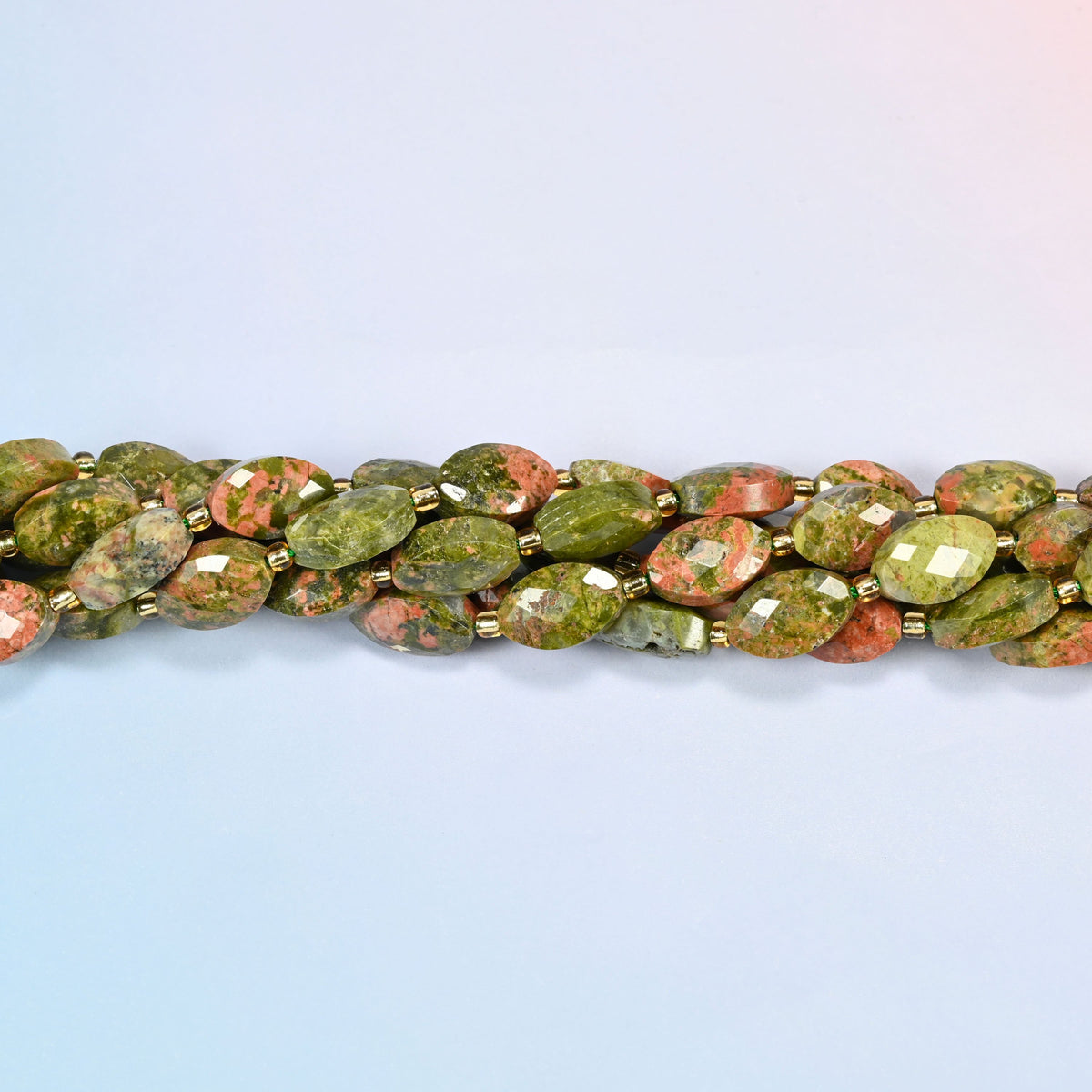 Strands of unakite faceted flat oval beads twisted together in a horizontal row