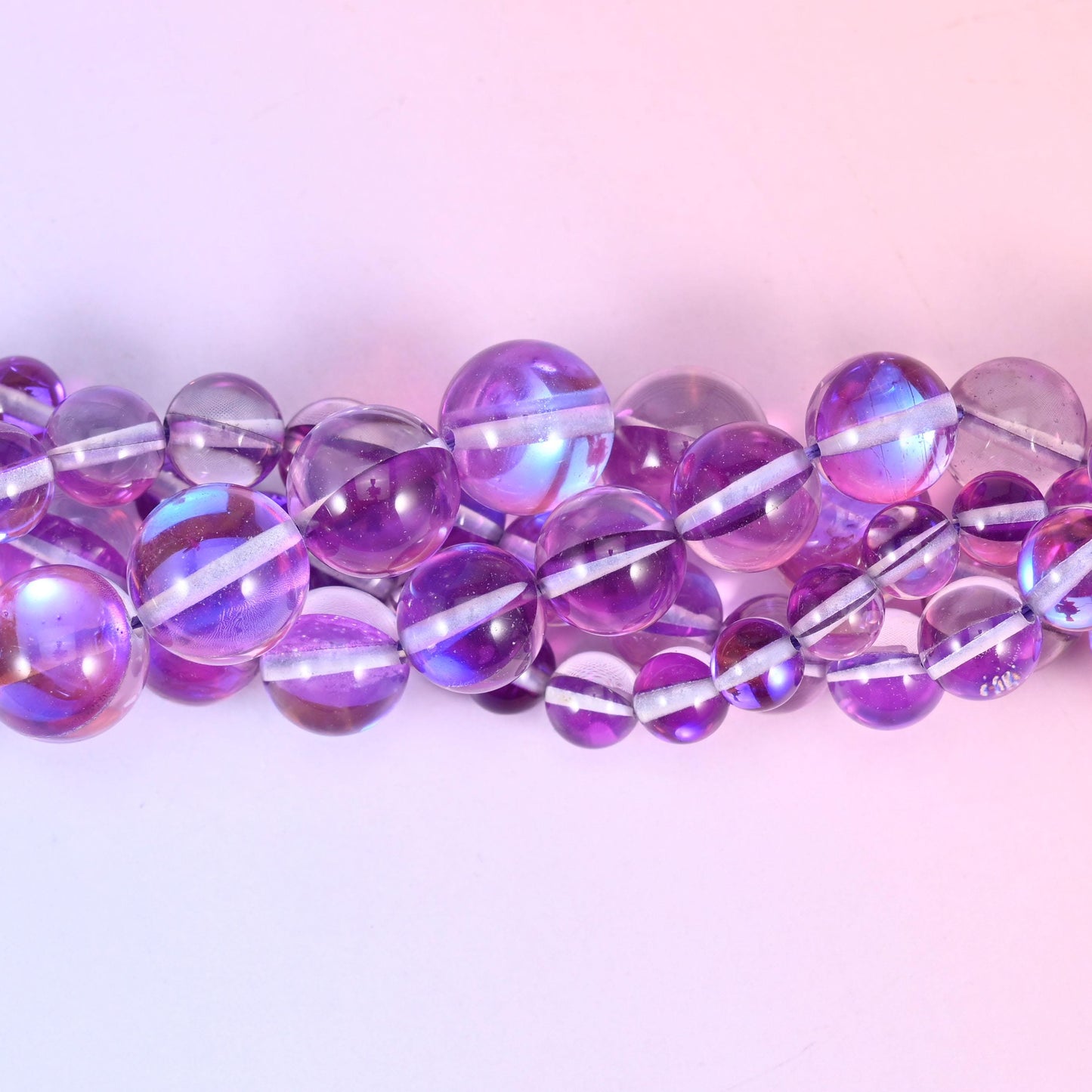 Transparent orchid purple glass beads with a blue-and-pink aurora band