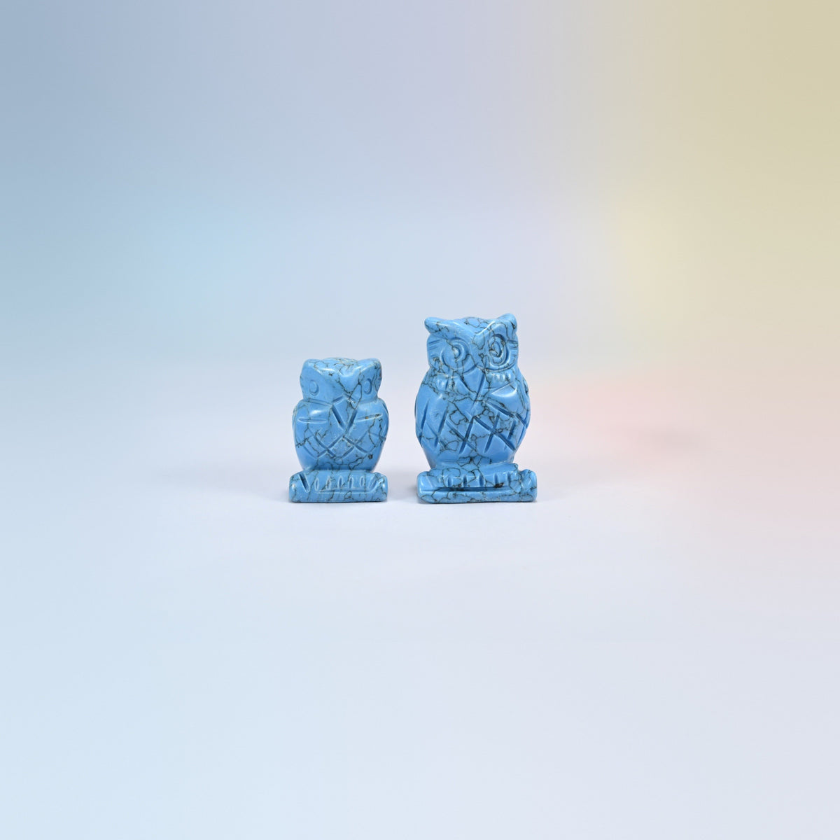 Owl crystal carving in dyed blue howlite, bright blue with dark veining