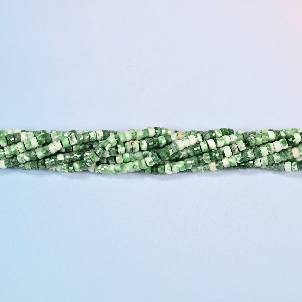 Strands of tree agate faceted heishi disc beads twisted together in a horizontal row