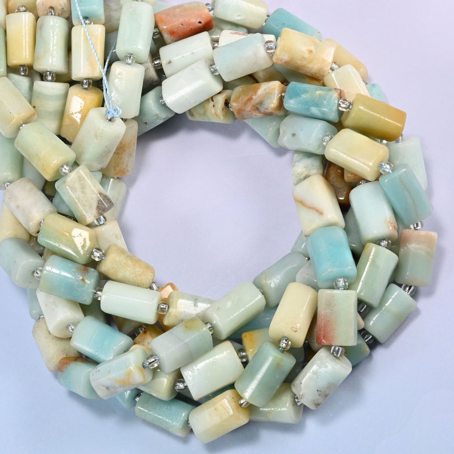Multi-Color Amazonite faceted tube beads coiled into a ring, colour running from light blue and green to cream and yellow bead to bead