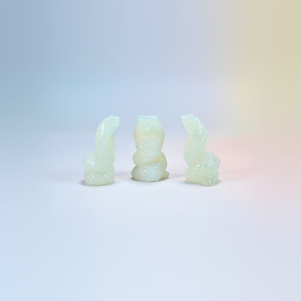 Cobra snake carving in opalite, milky white man-made glass with a blue glow