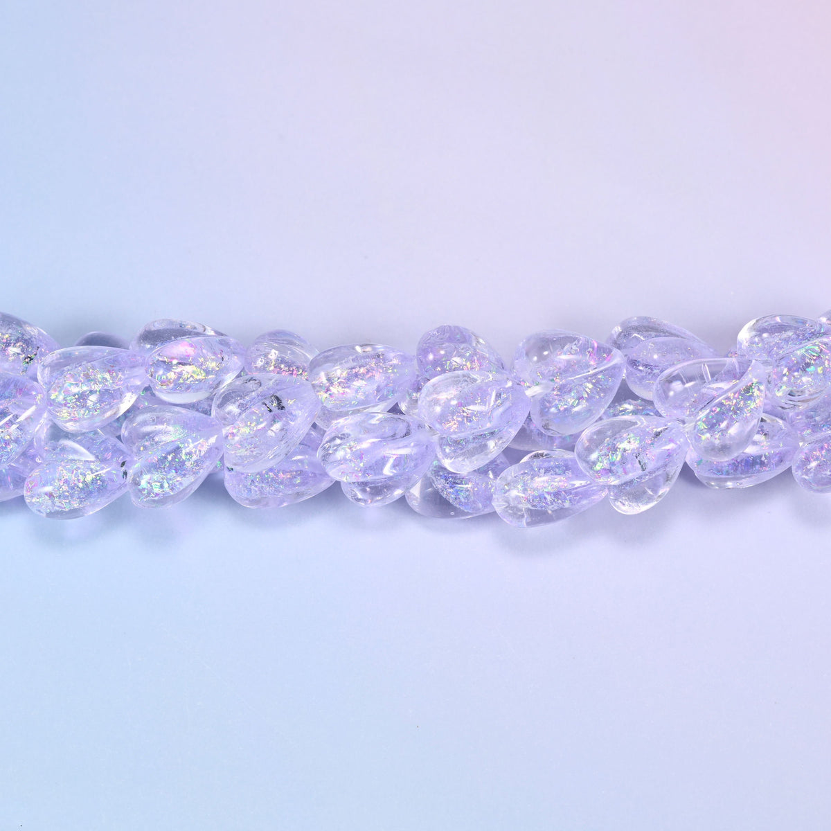 Transparent pale lilac glass hearts with a glittering iridescent shimmer that throws pink and silver flashes