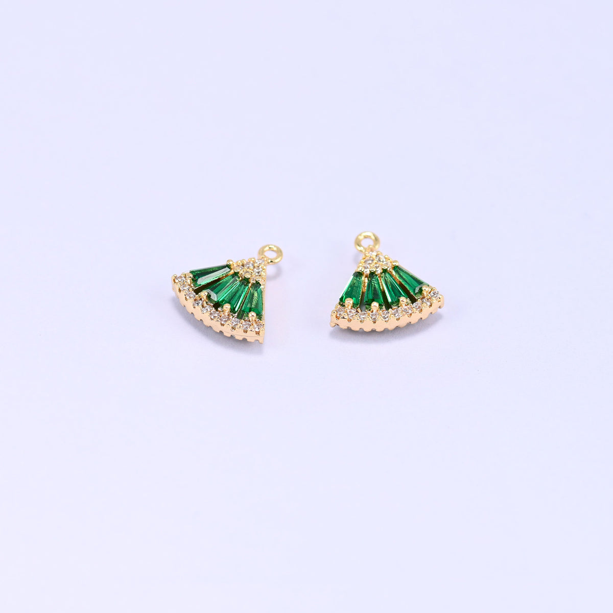 Small gold charms, two fan charms with green cubic zirconia shown close up