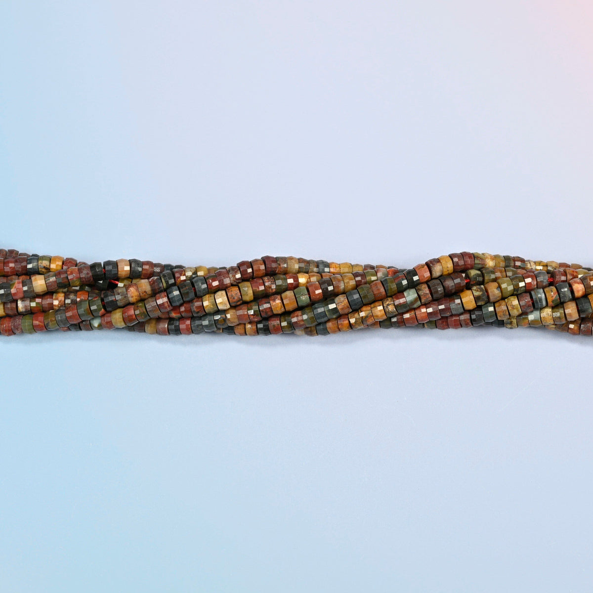 Strands of red howlite faceted heishi disc beads twisted together in a horizontal row