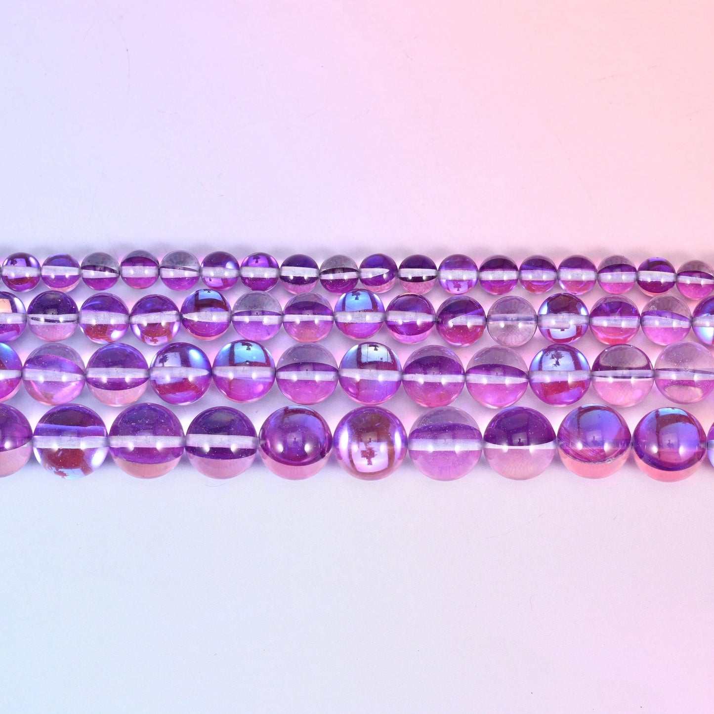 Mystic Aura beads in orchid purple glass with a blue-and-pink aurora band