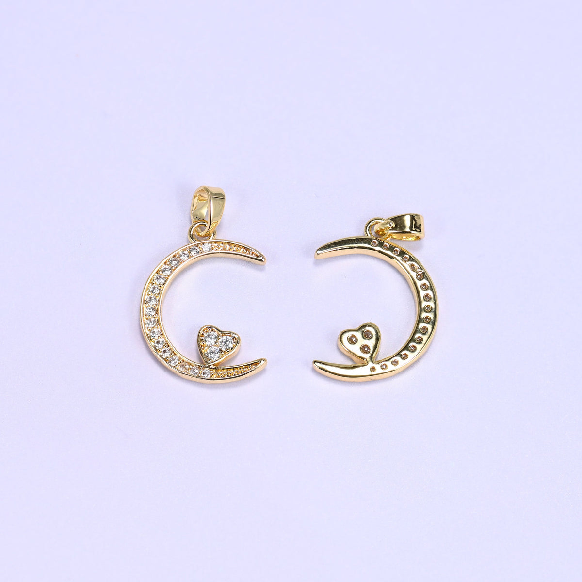 Gold moon heart zirconia charms front and back, one crescent pendant face up beside one flipped to the plain reverse.
