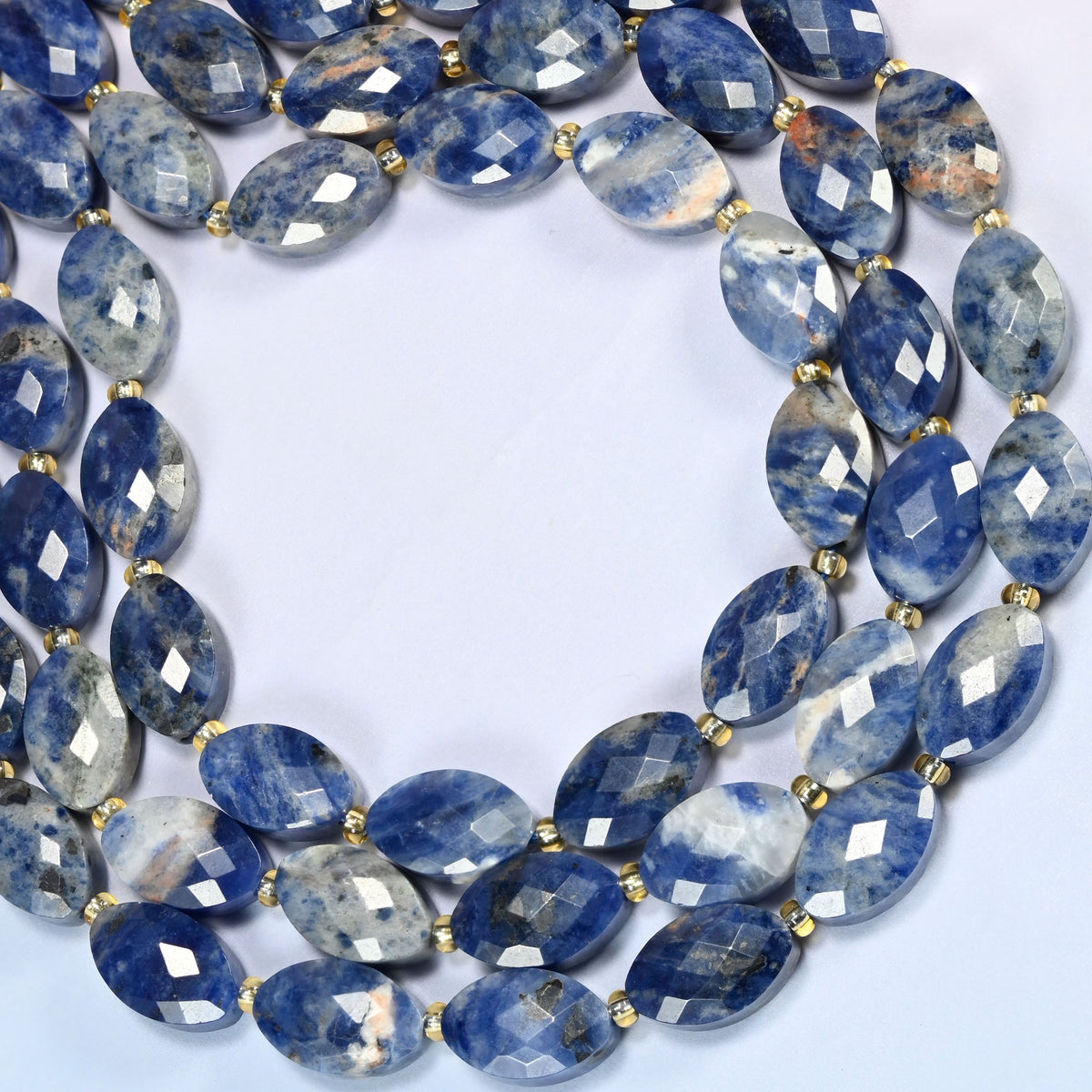 Orange sodalite faceted flat oval beads curved into an open loop, blue stone with orange patches