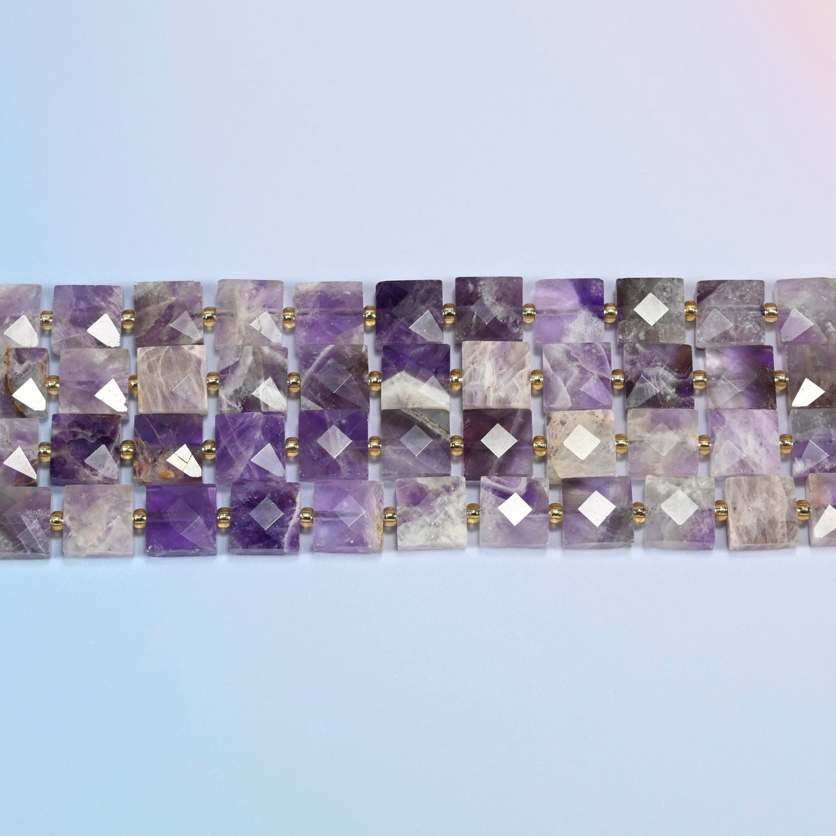 Several strands of natural amethyst faceted flat square beads laid in straight rows
