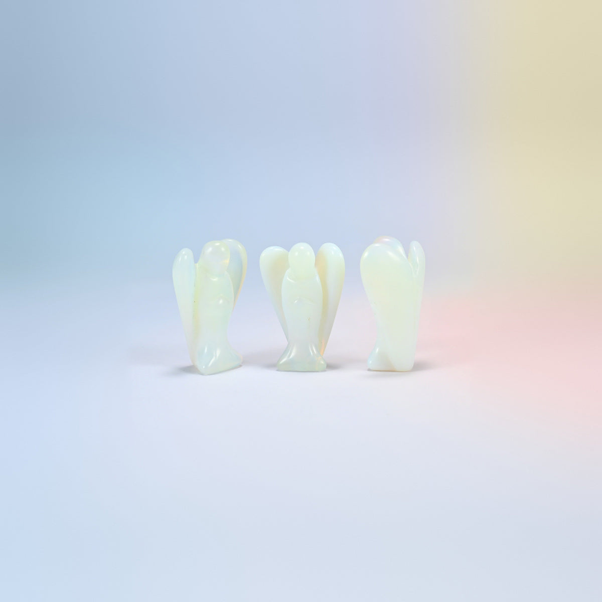 Three opalite guardian angel carvings, milky white with a blue glow, man-made glass, 2 inch