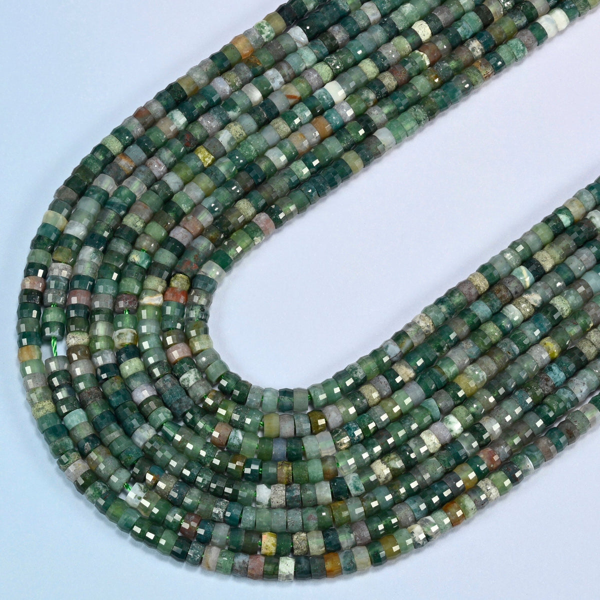 Indian agate faceted heishi disc beads in several strands curved into a wide U, forest green stone with white and brown flecks