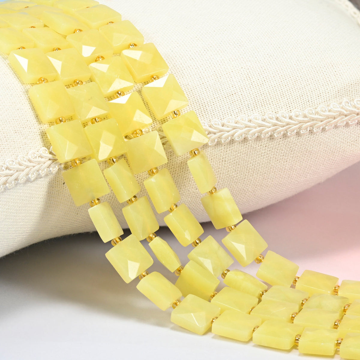 Lemon Jade faceted flat square beads 10x10mm with small gold seed bead spacers, several strands draped over a white cushion