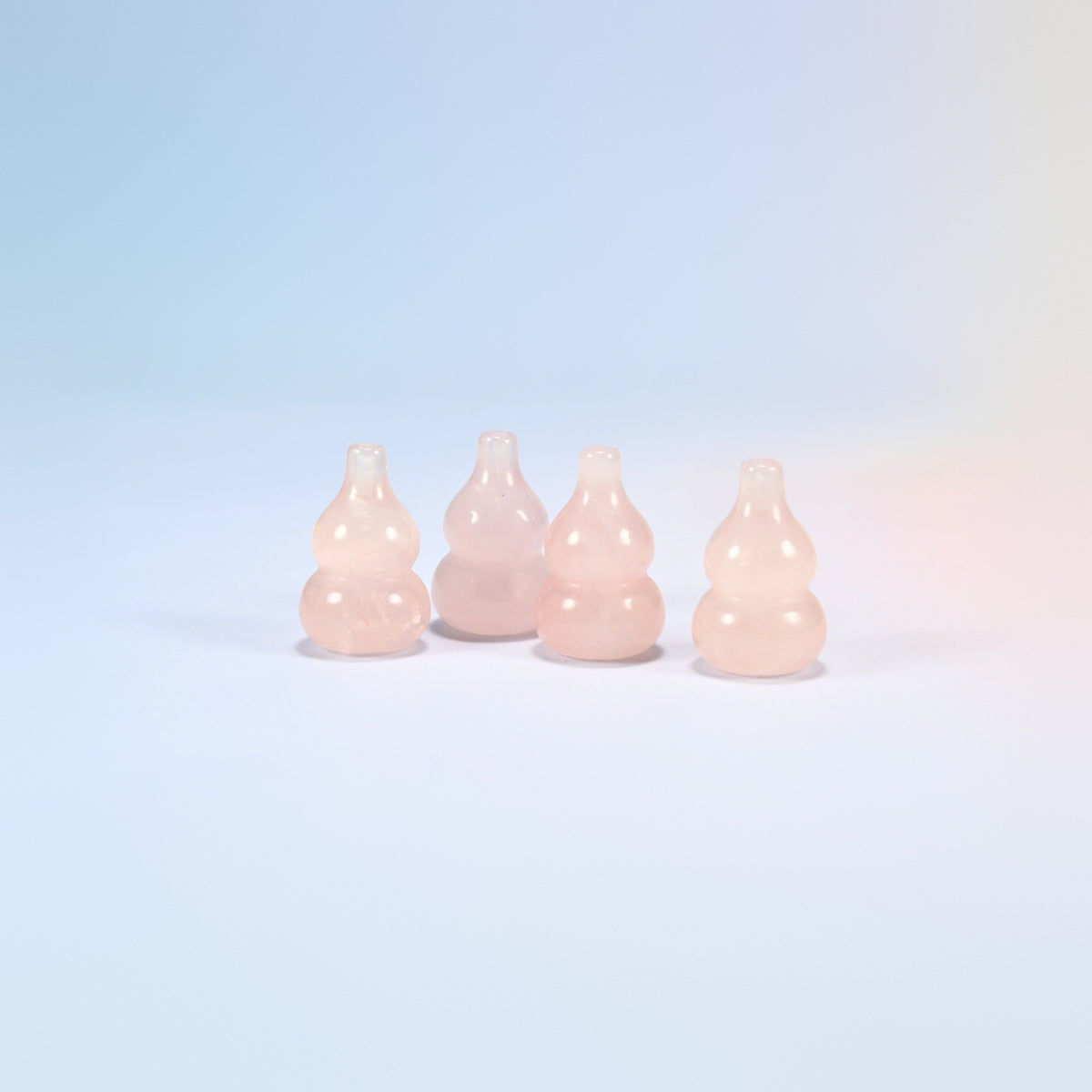Four 1.2 inch natural rose quartz gourds side by side