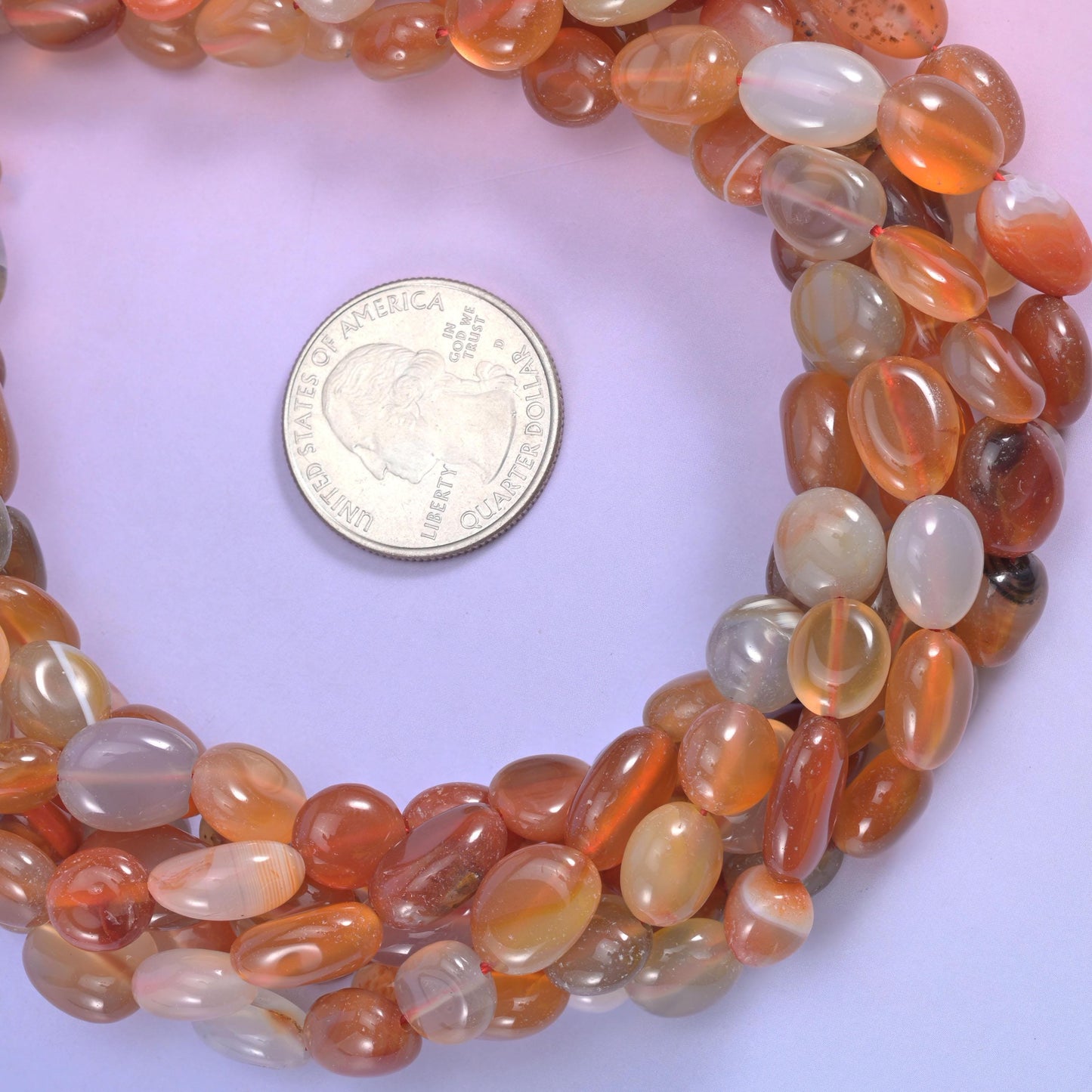Warm amber and rust orange pebbles shot through with milky grey-white and occasional smoky brown, polished glassy