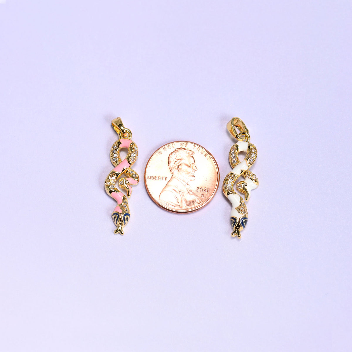 Enamel Snake Zirconia Charms photographed either side of a US penny, the pink and white coiled pendants clearly longer than the coin.